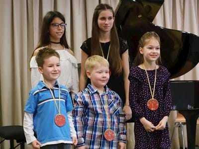 JugendKonzertMarathon 2019.JPG Für die Teilnehmerinnen und Teilnehmer des JugendKonzertMarathons Timea (13) und Eszter Gal (14, hintere Reihe v.l.n.r.) sowie Gustav Krell (6), Max Koch (5) und Greta Krell (8, vordere Reihe v.l.n.r.) gab es eigens getöpferte Medaillen.